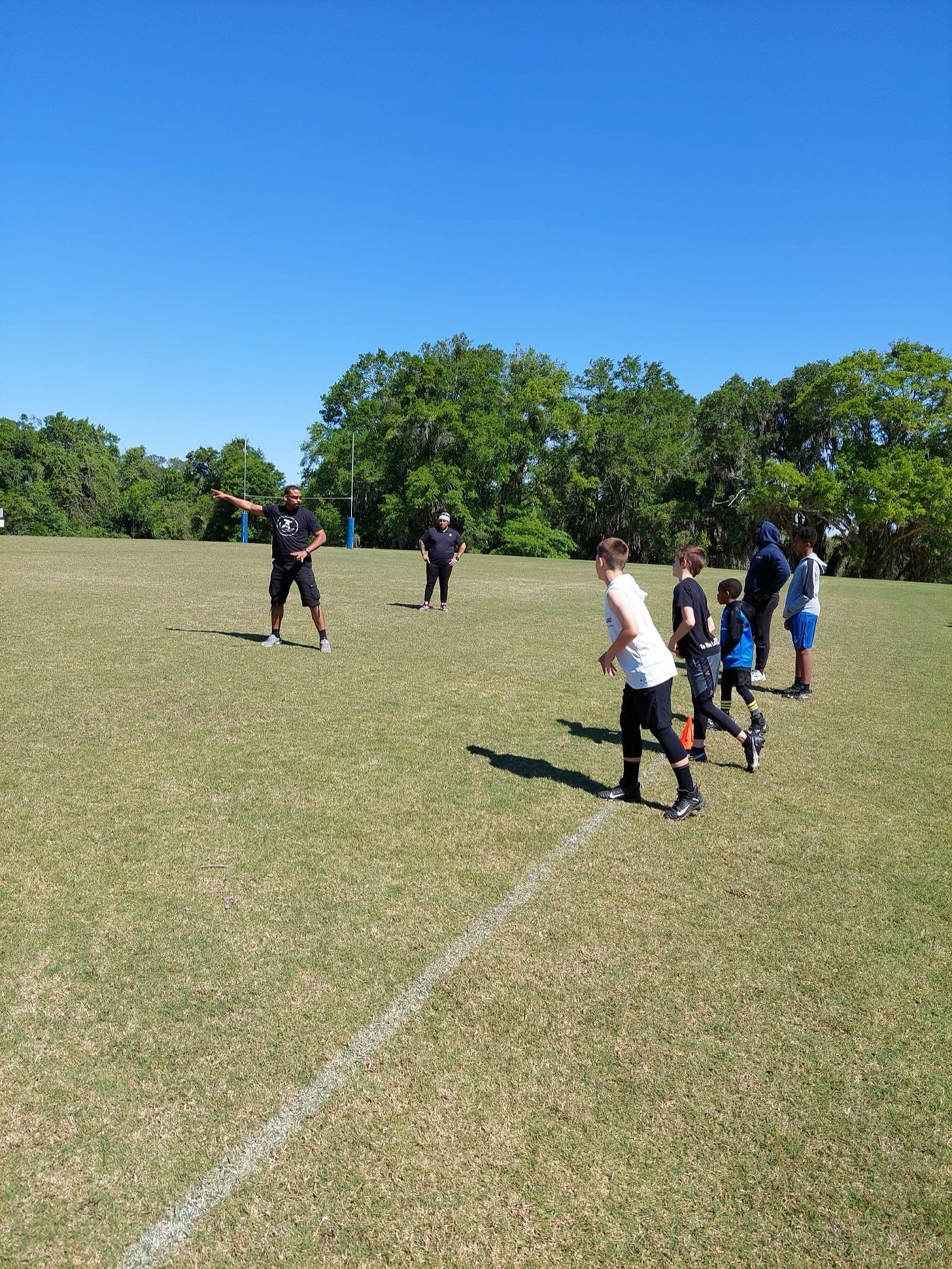 Technique Athletes coaches leading a youth training session on the field